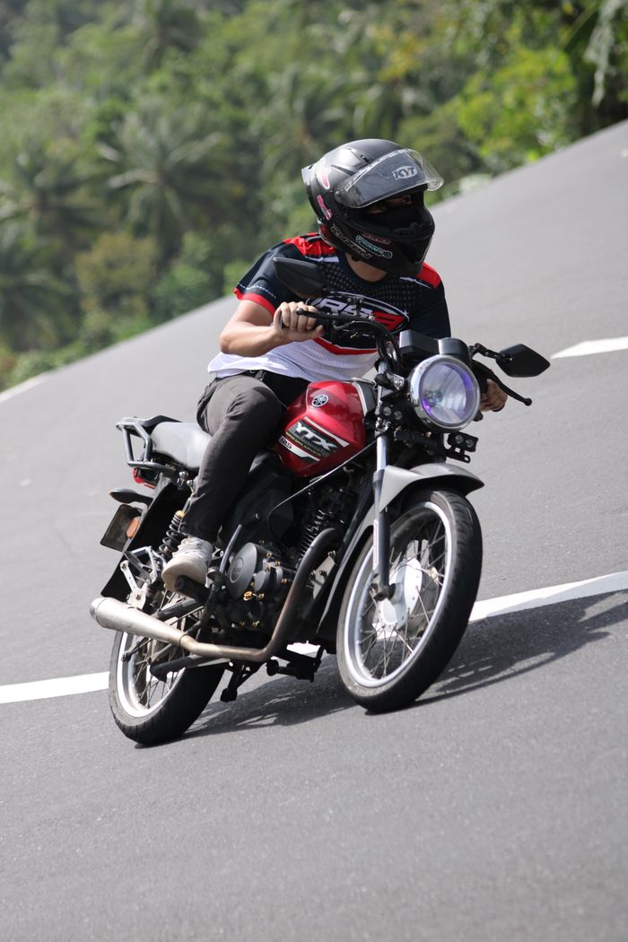 Motorcyclist skillfully riding through a winding road on a sunny day.