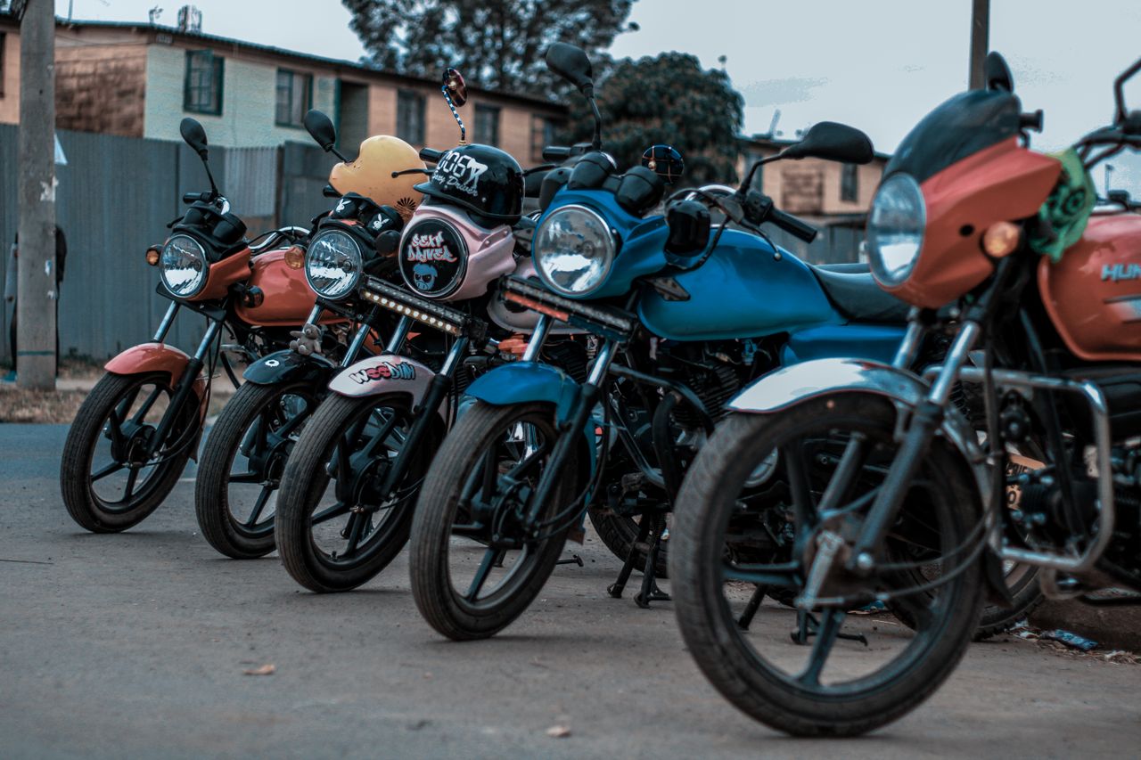 Vibrant motorcycles lined up along a city street, showcasing urban life.